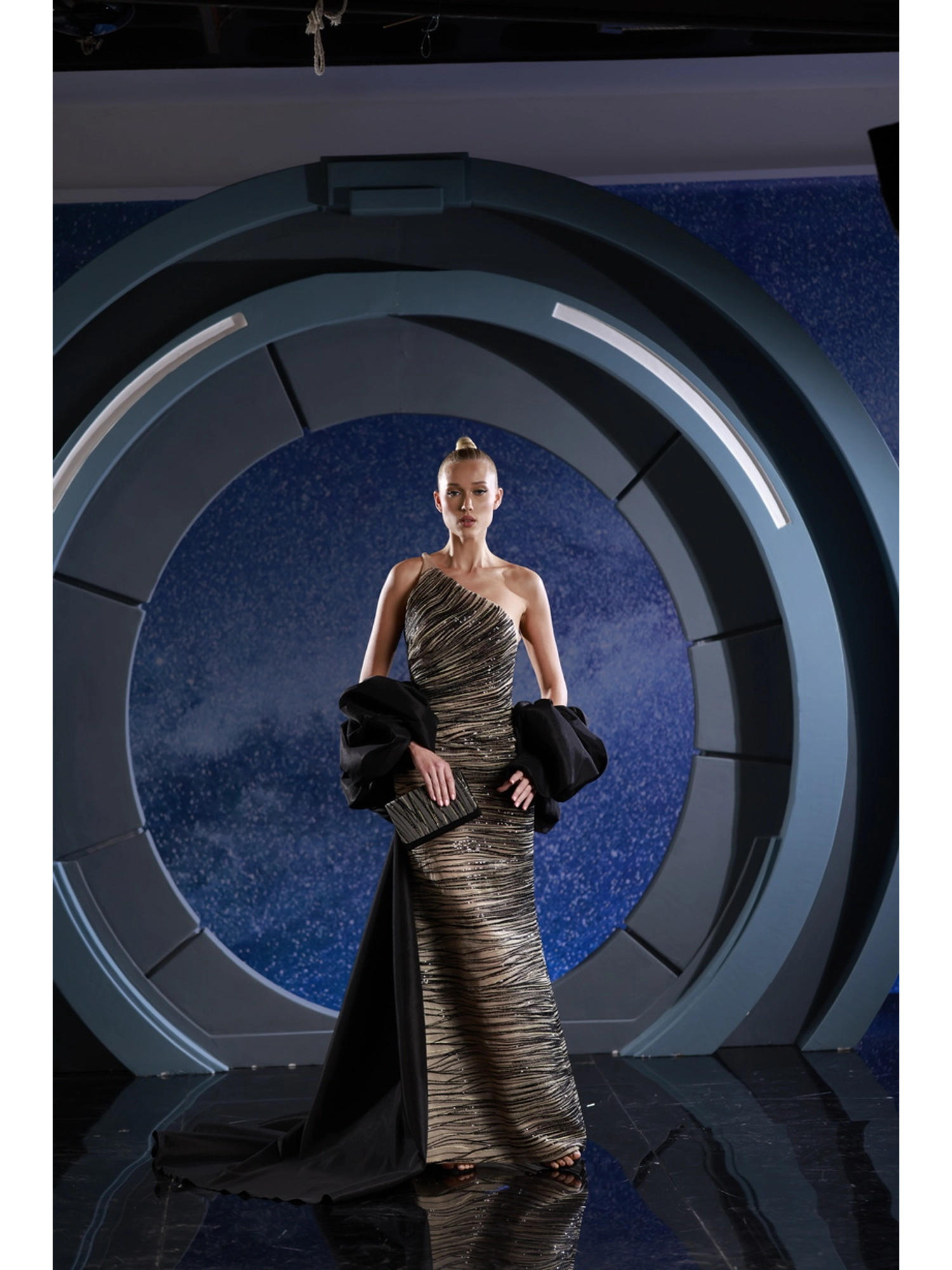 FW 114 - One-shoulder dress with striking black and gold lace,  completing the look is a black taffeta train and a  detachable bolero. Gold US 01